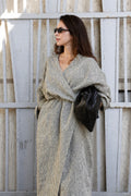 Woman wearing a striped linen kimono wrap dress with oversized sleeves and an adjustable waist tie.